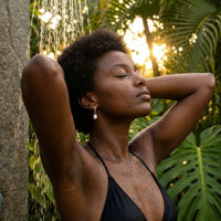 Thumbnail for Pearl Drop Huggie Hoops in Gold, worn in a tropical outdoor shower | SKU: 41003-gold