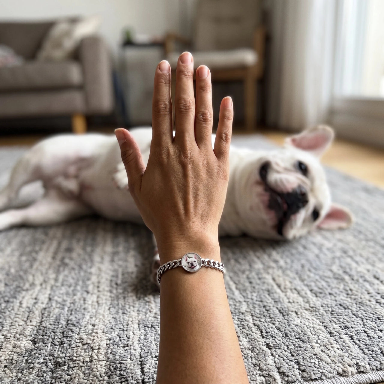 Customer photo: the silver round bracelet with her bulldog's photo, her dog in the background | SKU: TPH-RNDB-SILVER