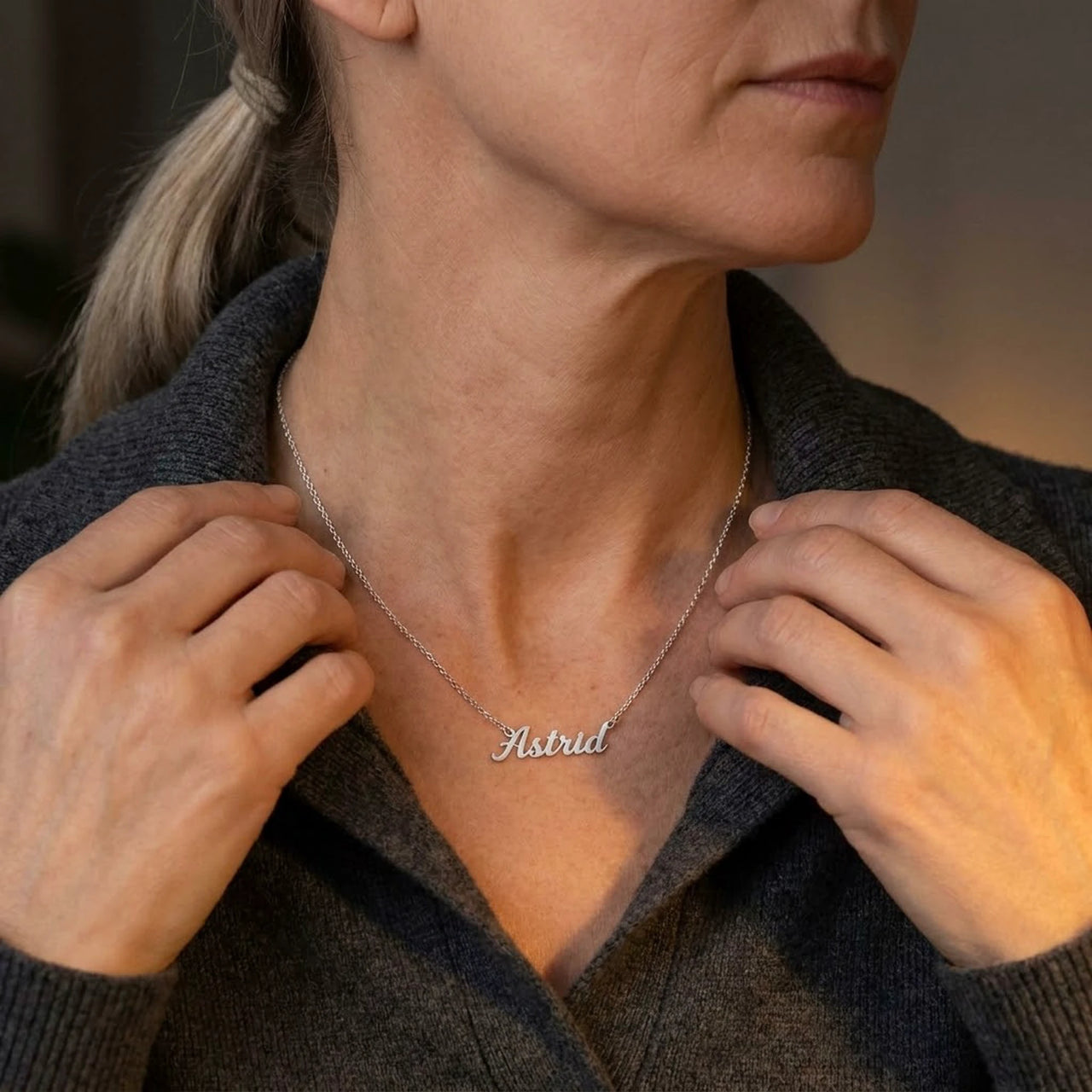 Minimalist Name Necklace in silver held at the neckline with both hands, the name Astrid | SKU: minimalistnn-silver