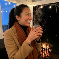 Thumbnail for Woman wearing the rose gold Crystal Bar Bracelet on a winter terrace beside a fire basket